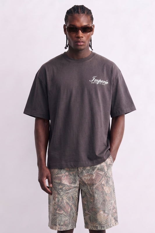 Camiseta oversize gris antracita con pequeño texto claro en el pecho, vista frontal.