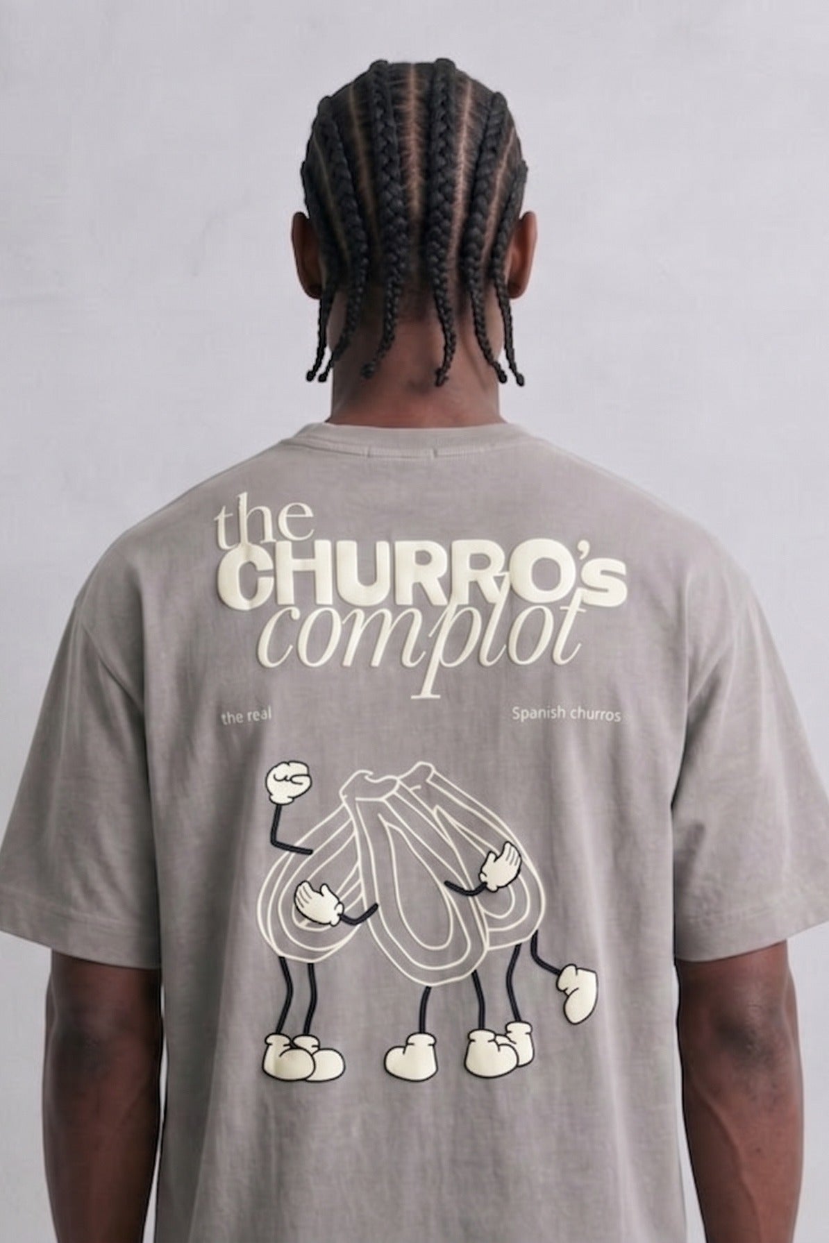 Espalda de camiseta gris The Churros Complot con dibujo claro de personajes de churros.