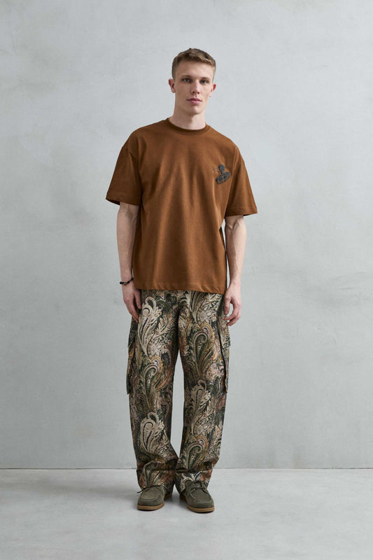 Vista frontal de cuerpo entero de la camiseta oversize marrón Duck Records, con manga corta amplia, hombros caídos y bajo recto.