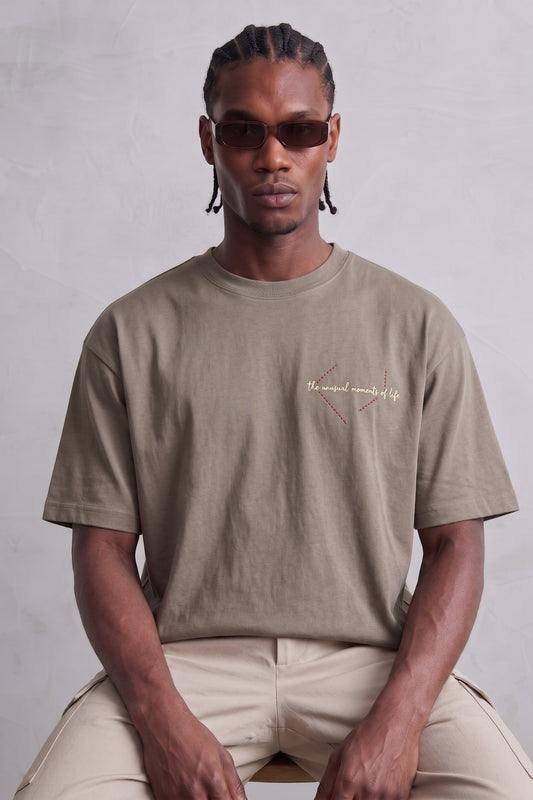 Camiseta oversize color topo con pequeño texto claro en el pecho, vista frontal.