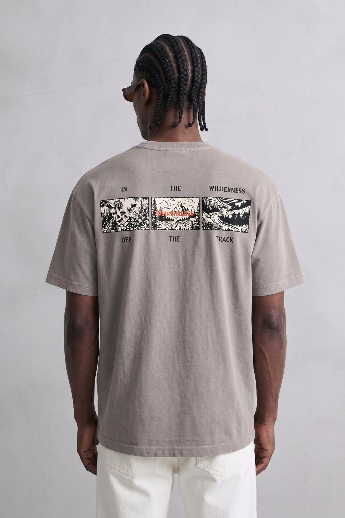 Espalda de camiseta topo con tres viñetas rectangulares de ilustraciones en negro, blanco y detalles rojos.