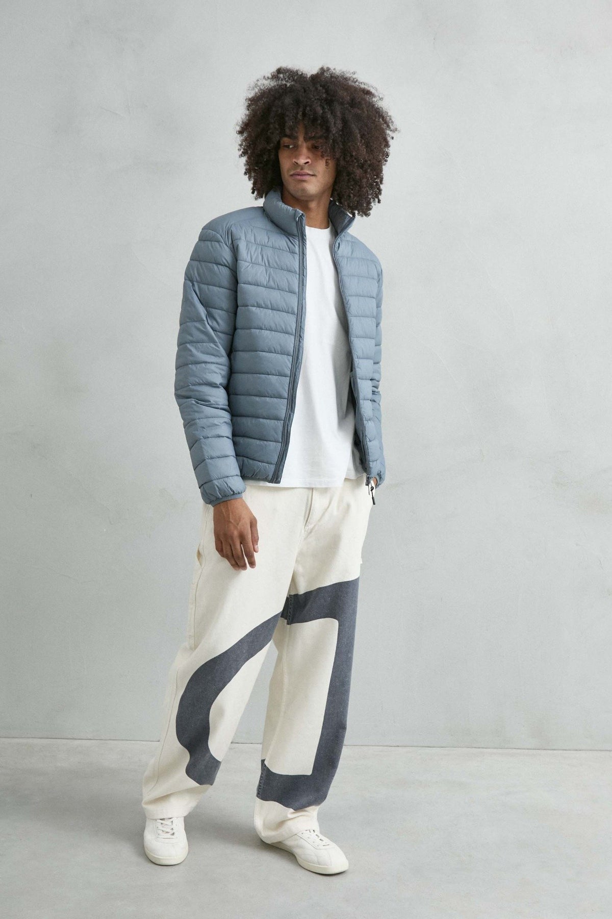 Chaqueta acolchada de hombre azul grisáceo con cuello alto y cremallera de doble cursor, vista look.