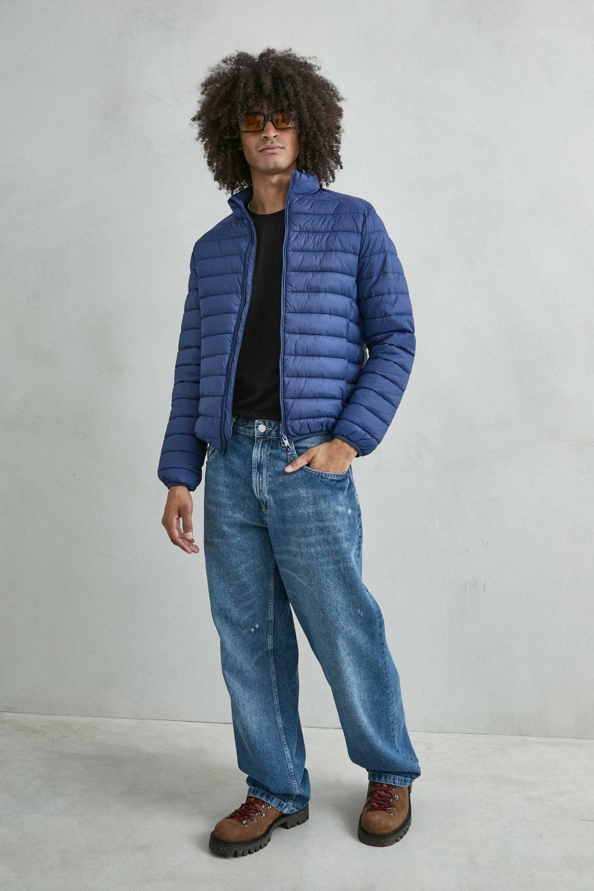 Chaqueta acolchada de hombre azul con cuello alto y cremallera de doble cursor, vista look.