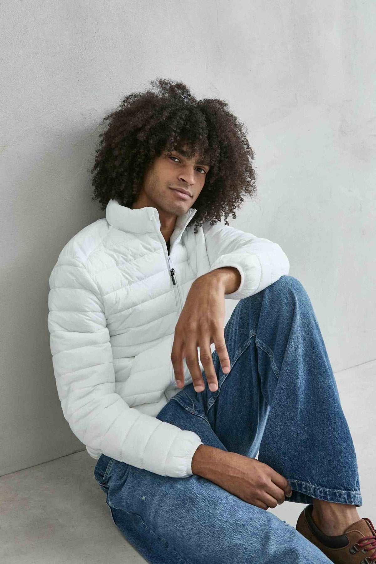 Chaqueta acolchada de hombre blanco con cuello alto y cremallera de doble cursor, vista detalle.