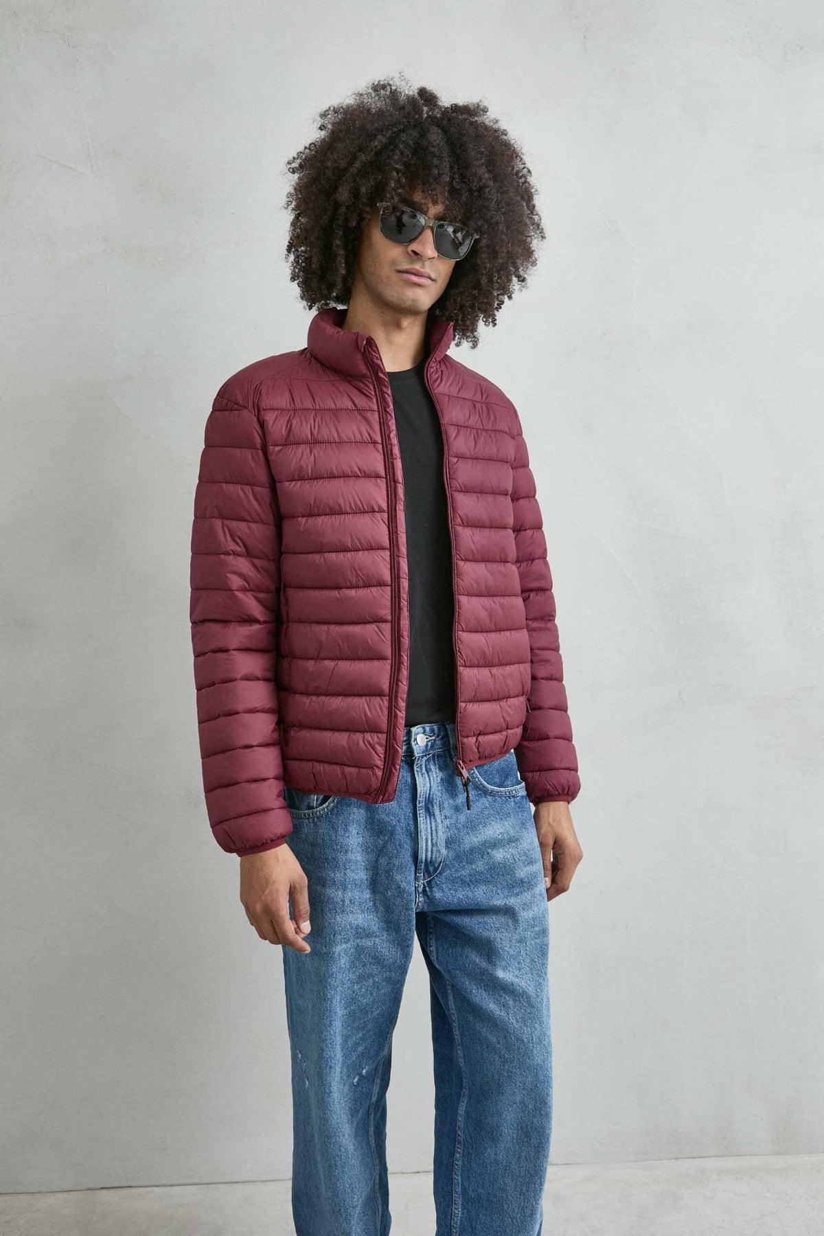 Chaqueta acolchada de hombre burdeos con cuello alto y cremallera de doble cursor, vista frontal.