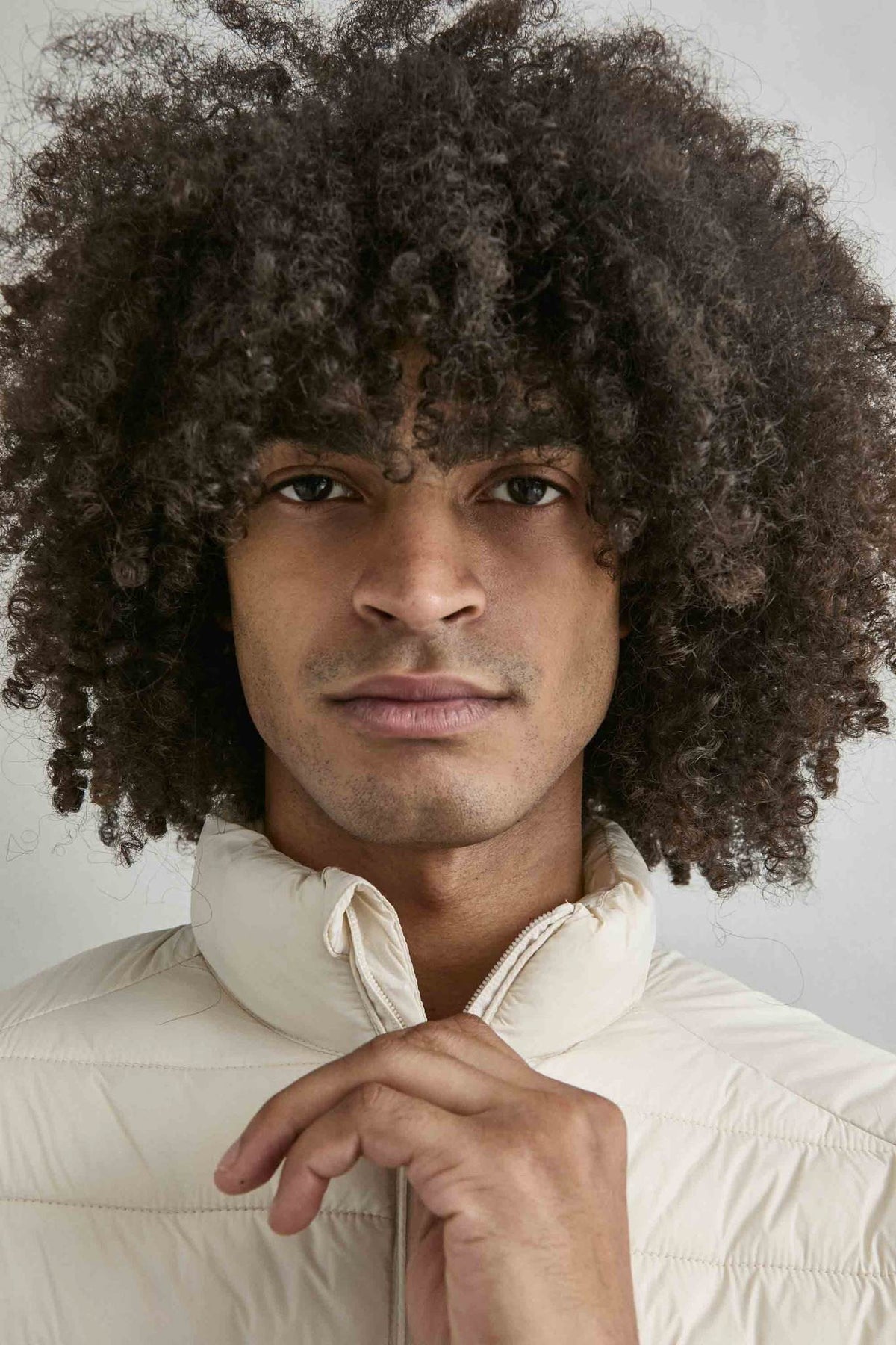 Chaqueta acolchada de hombre crema con cuello alto y cremallera de doble cursor, vista detalle.