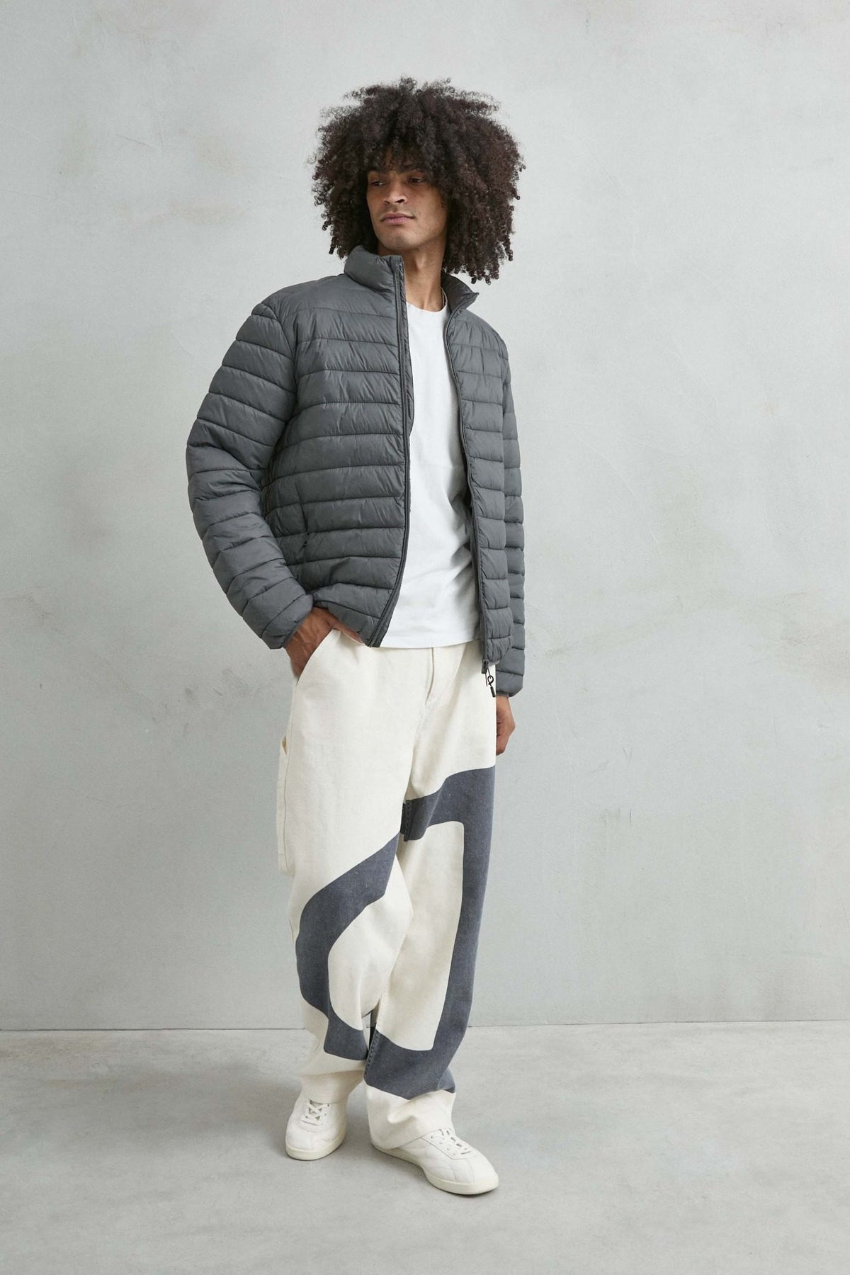 Chaqueta acolchada de hombre gris con cuello alto y cremallera de doble cursor, vista look.