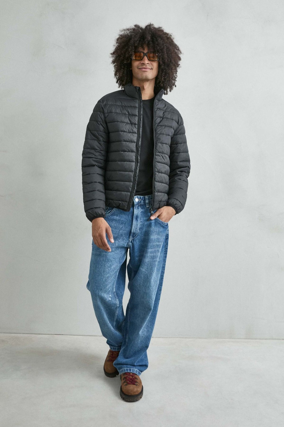 Chaqueta acolchada de hombre negro con cuello alto y cremallera de doble cursor, vista look.