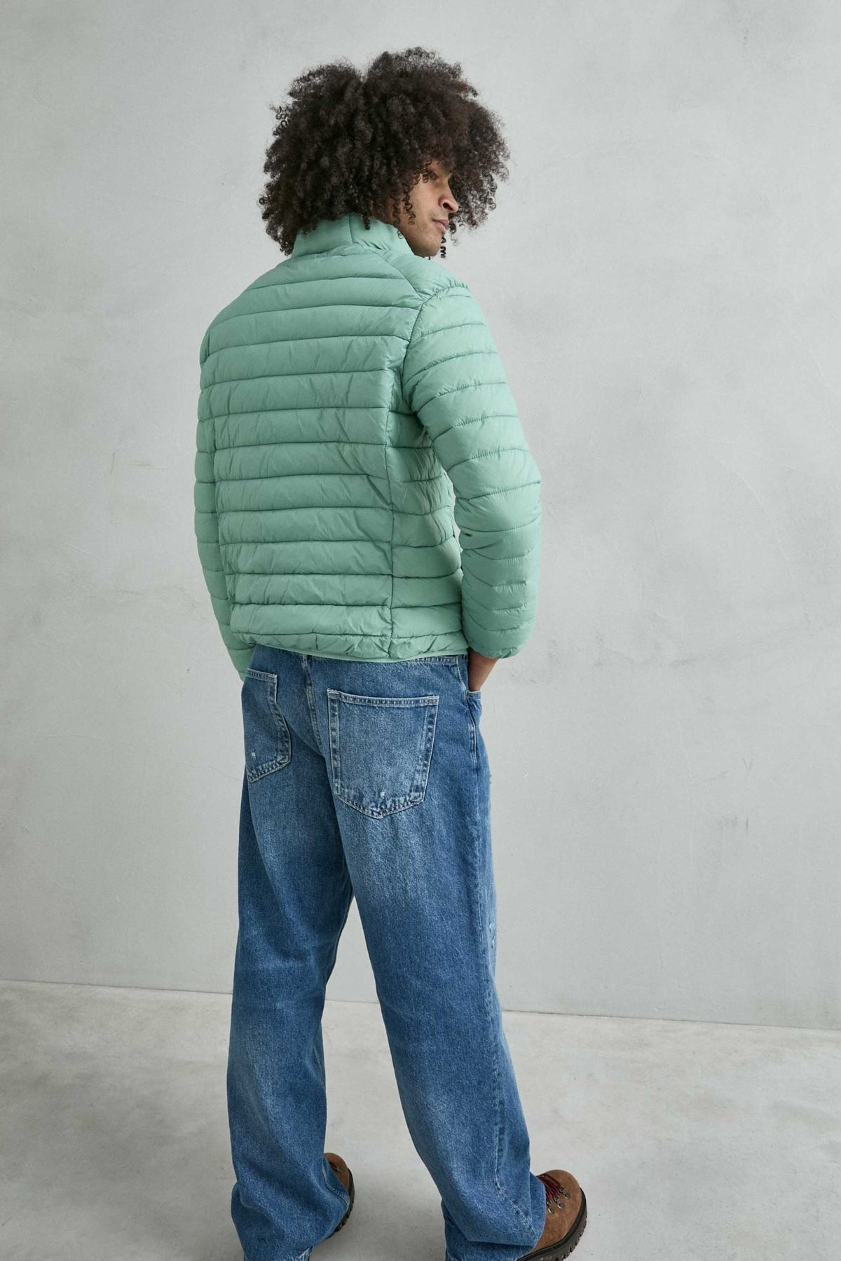 Chaqueta acolchada de hombre verde menta con cuello alto y cremallera de doble cursor, vista espalda.