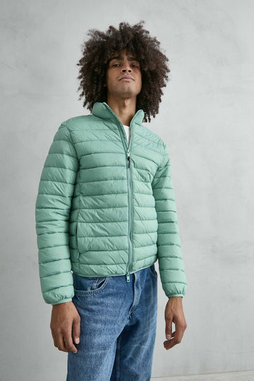 Chaqueta acolchada de hombre verde menta con cuello alto y cremallera de doble cursor, vista frontal.
