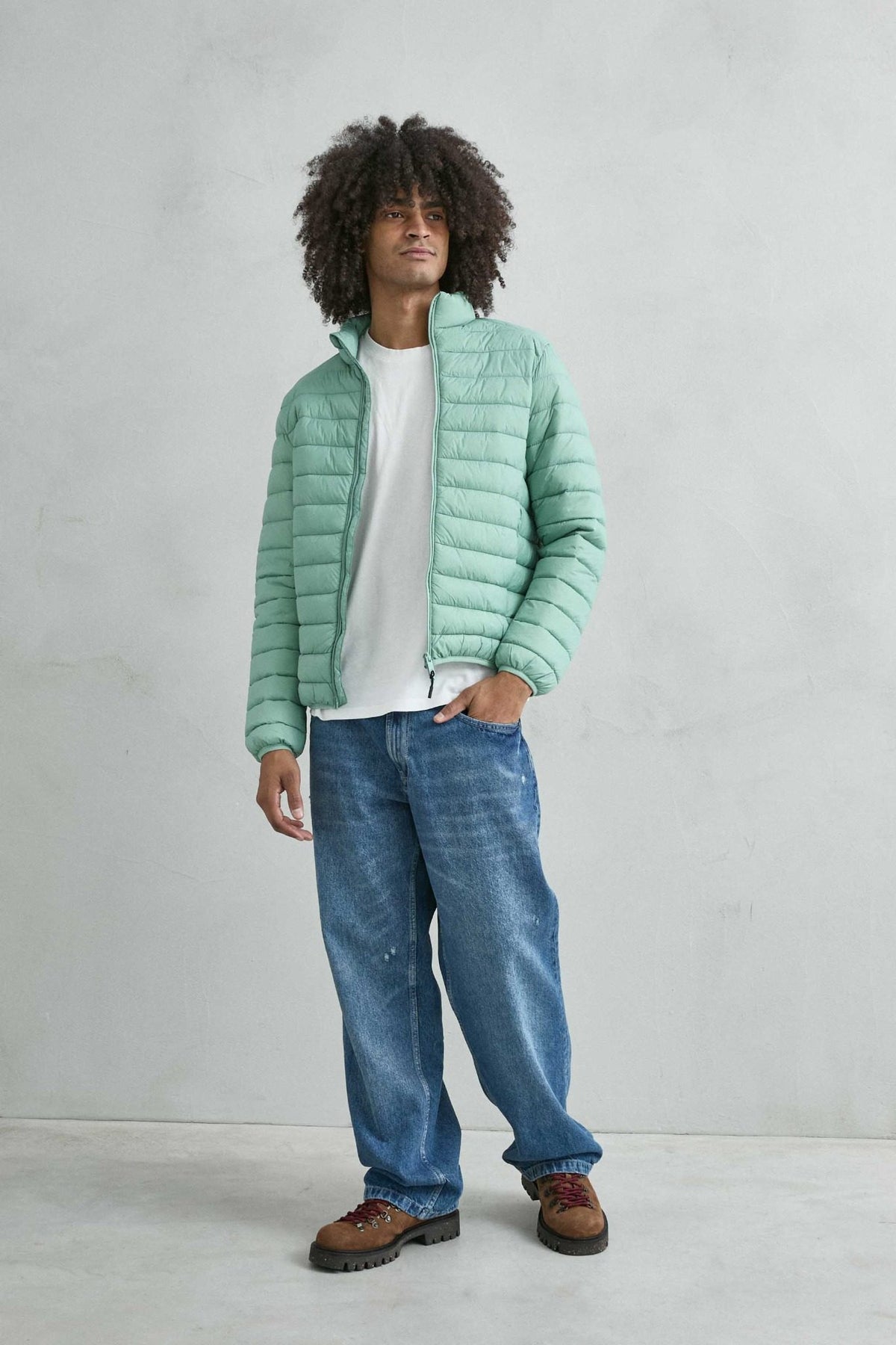Chaqueta acolchada de hombre verde menta con cuello alto y cremallera de doble cursor, vista de cuerpo entero.