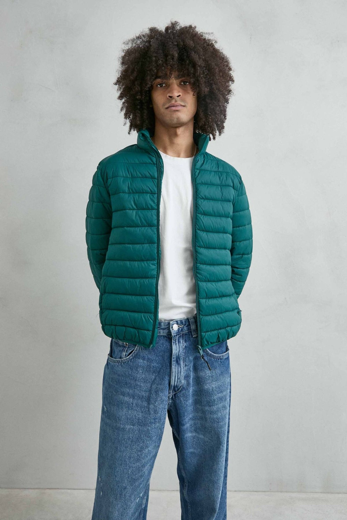Chaqueta acolchada de hombre verde oscuro con cuello alto y cremallera de doble cursor, vista detalle.