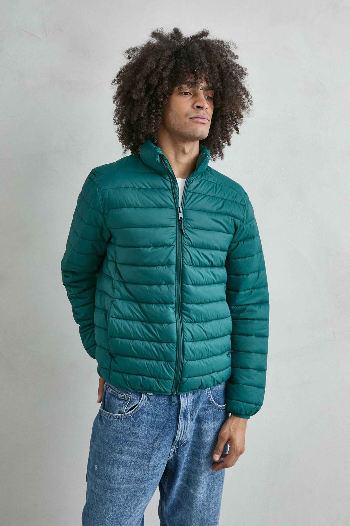 Chaqueta acolchada de hombre verde oscuro con cuello alto y cremallera de doble cursor, vista frontal.