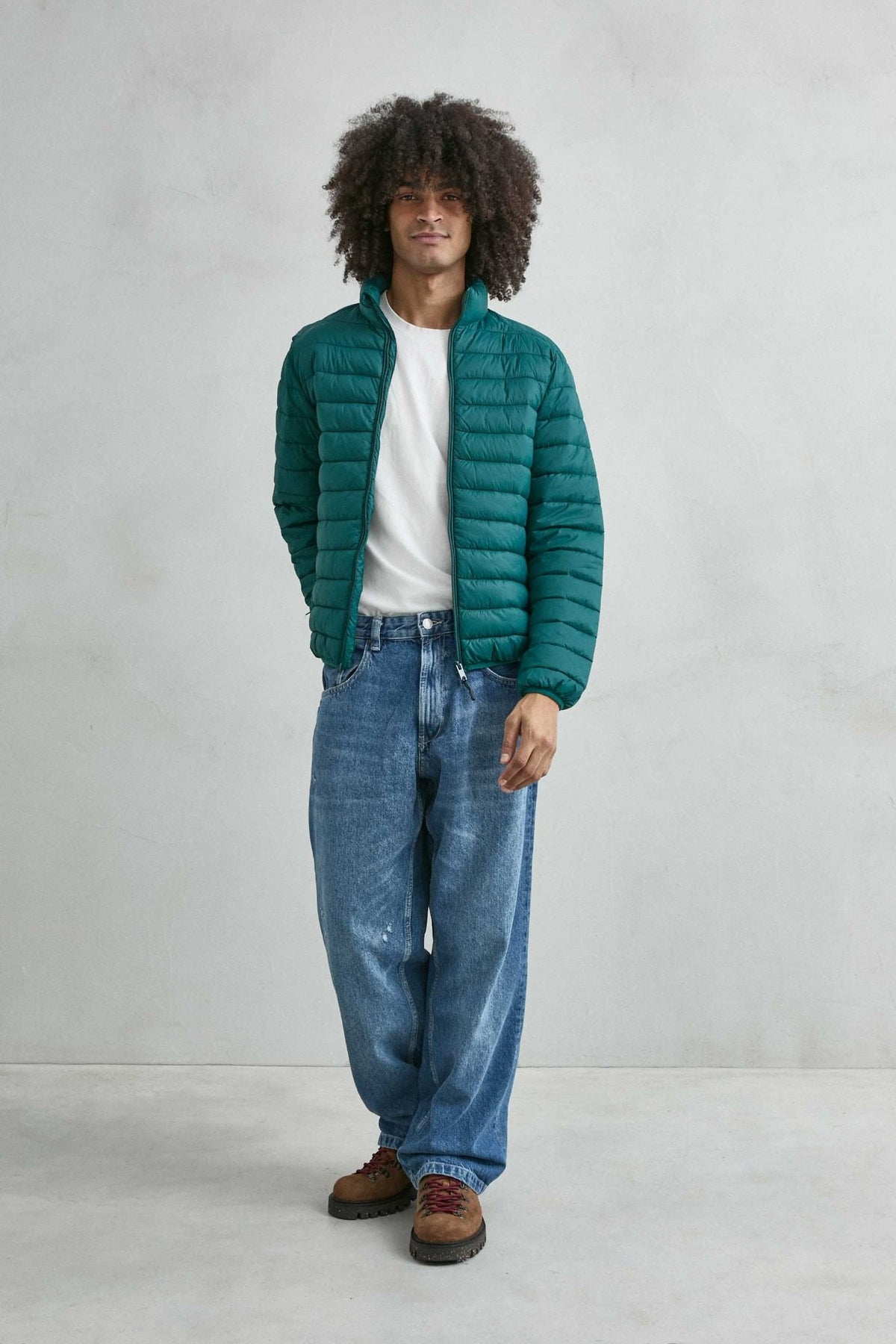 Chaqueta acolchada de hombre verde oscuro con cuello alto y cremallera de doble cursor, vista de cuerpo entero.