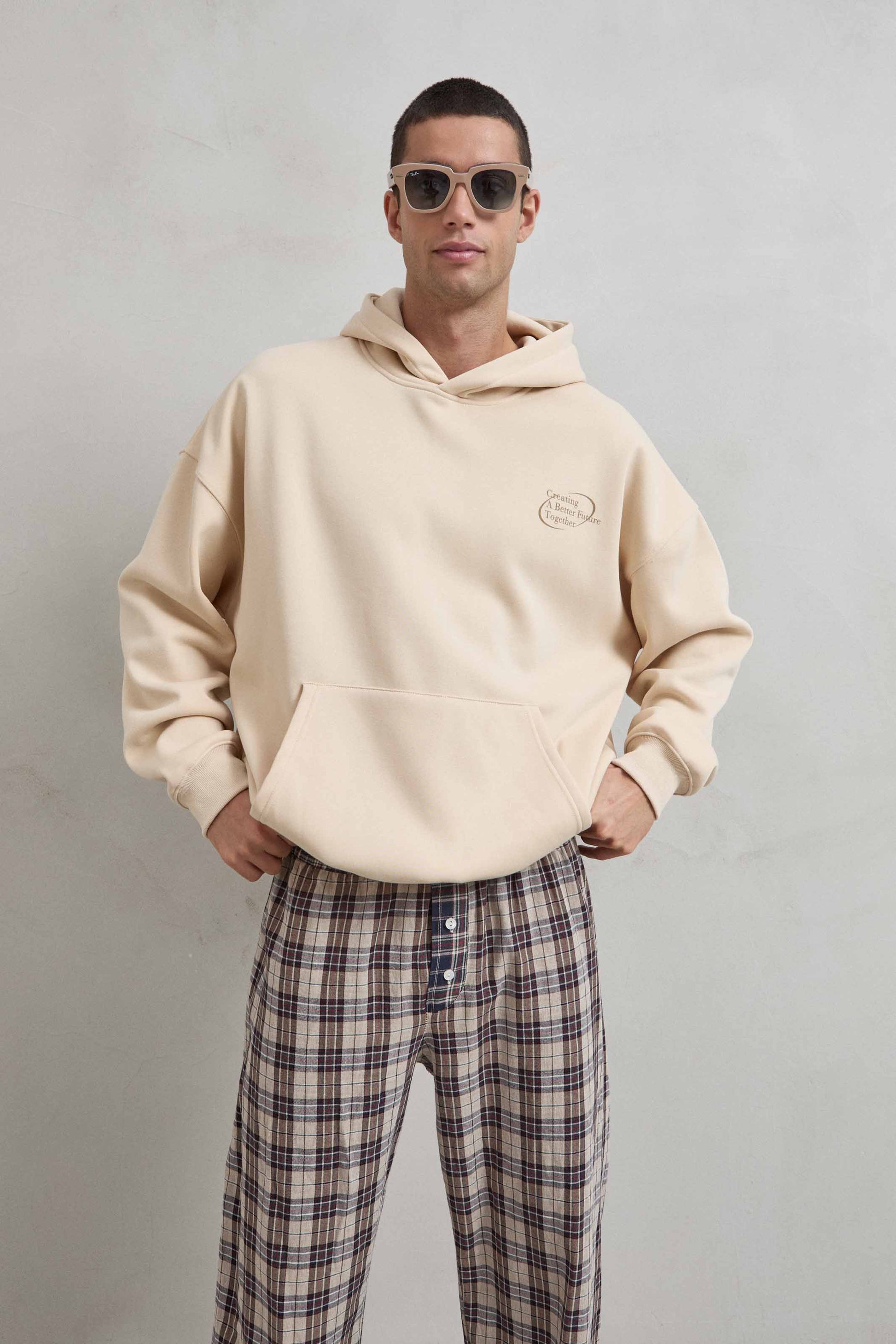 Sudadera beige con texto CREATING A BEAUTY FUTURE en el frente