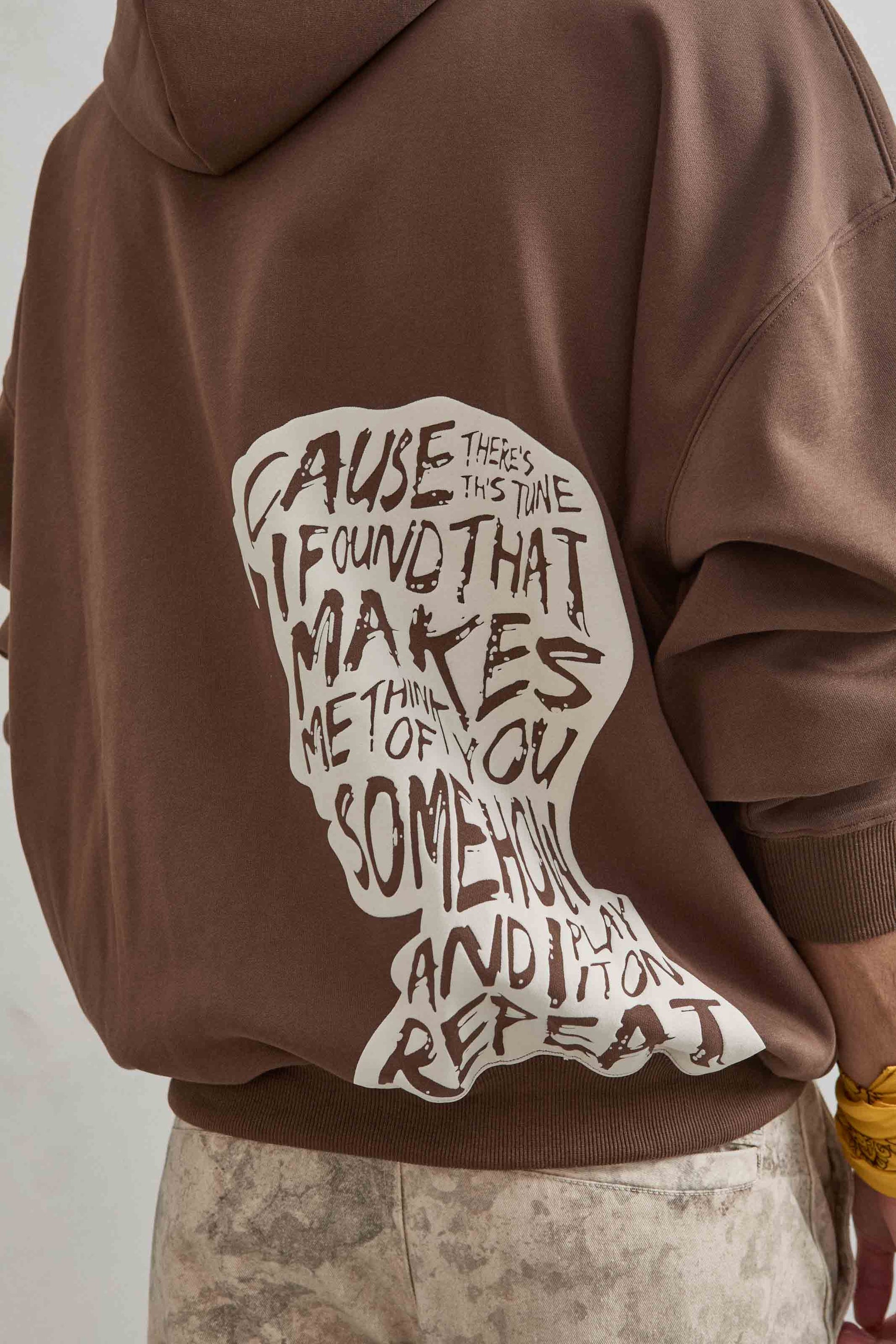 Sudadera marrón con estampado en relieve de cabeza en la espalda