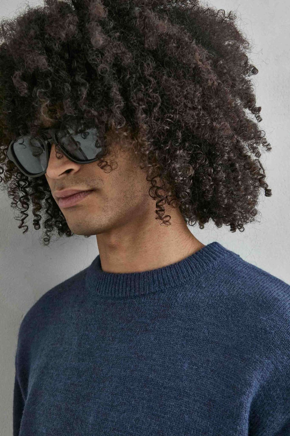 Detalle del tejido de punto y los acabados del jersey liso oversize de hombre en azul marino