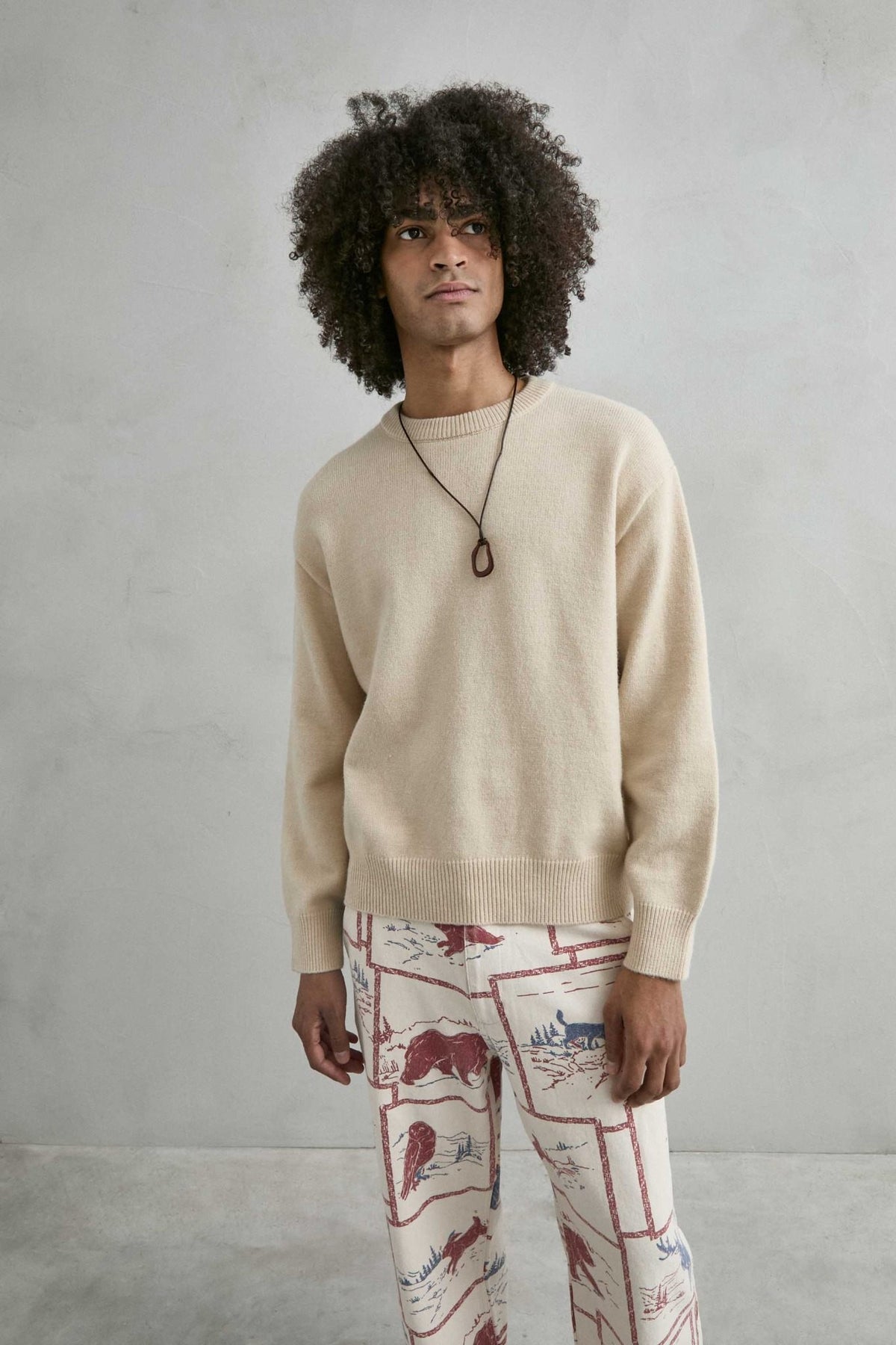 Vista frontal de medio cuerpo del jersey liso oversize de hombre en beis