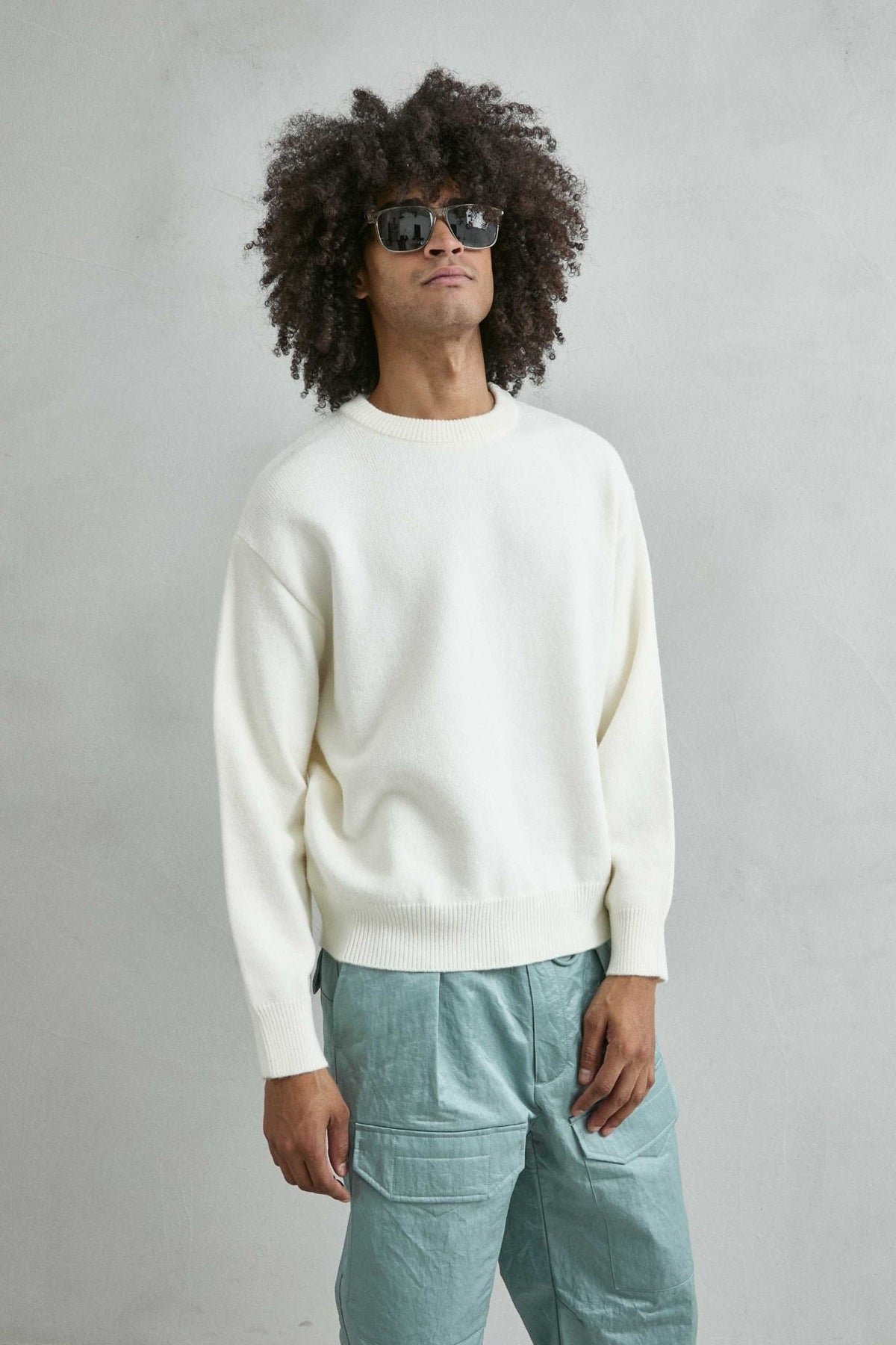 Vista frontal de medio cuerpo del jersey liso oversize de hombre en blanco roto