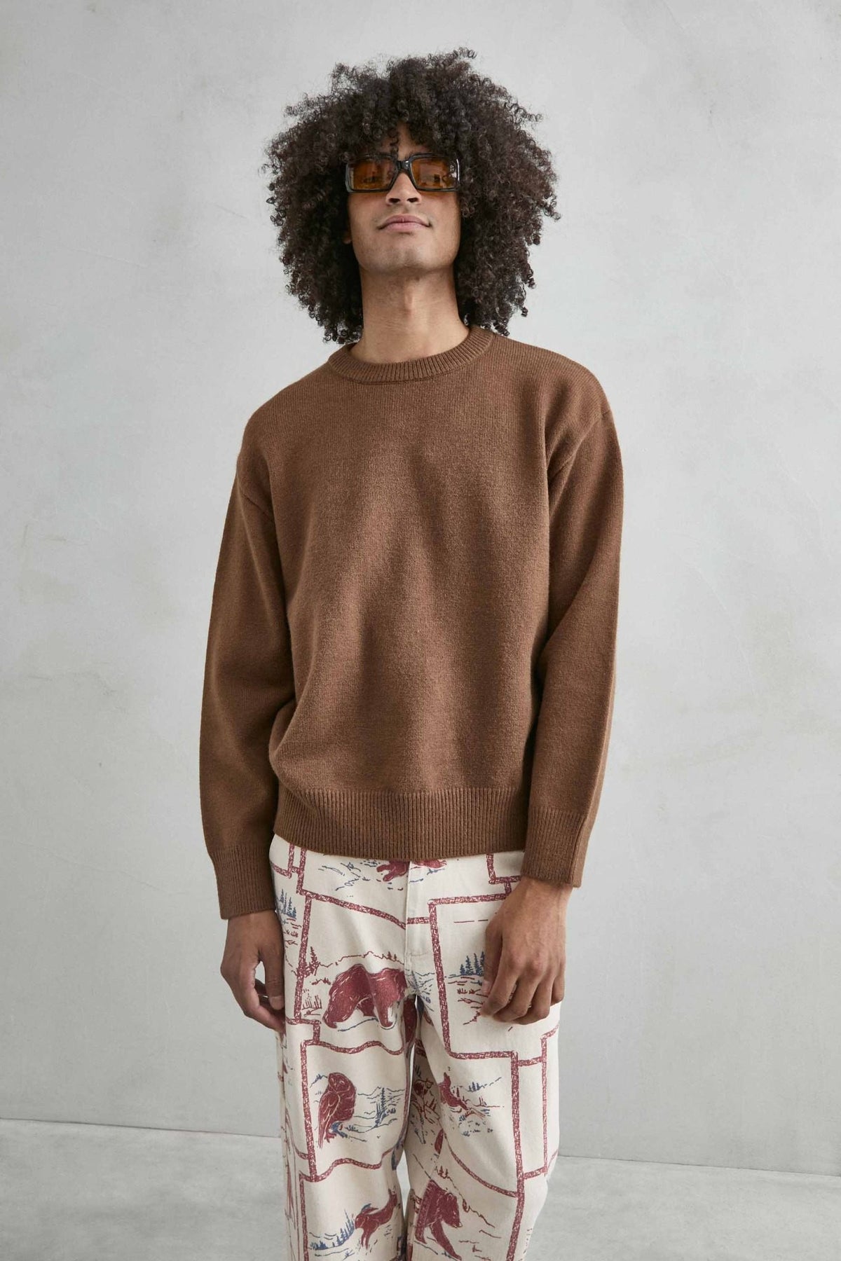Vista frontal de medio cuerpo del jersey liso oversize de hombre en marrón