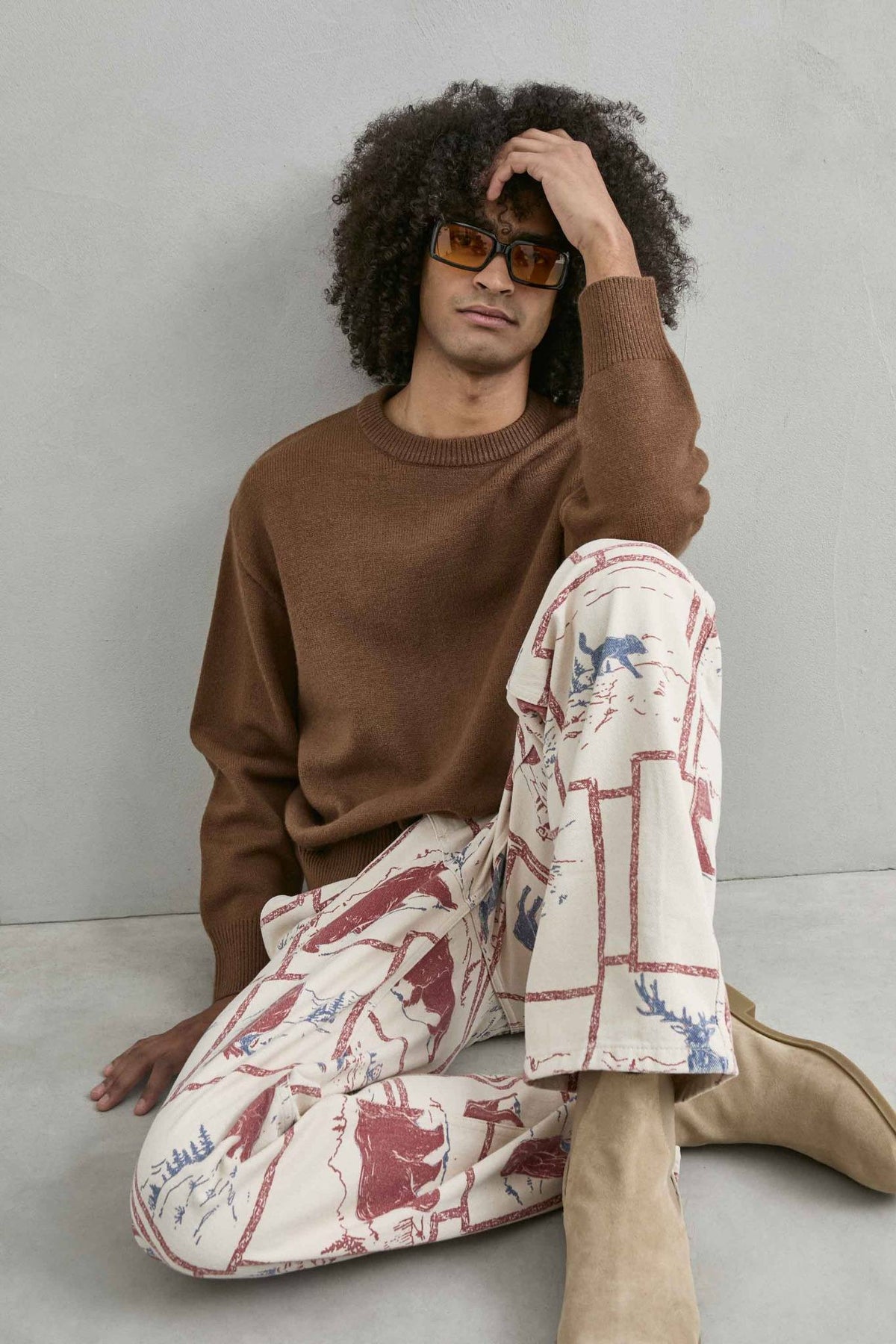 Vista del jersey con el modelo sentado del jersey liso oversize de hombre en marrón