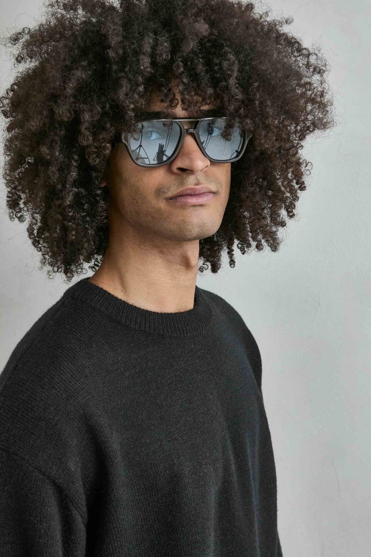Detalle del tejido de punto y los acabados del jersey liso oversize de hombre en negro