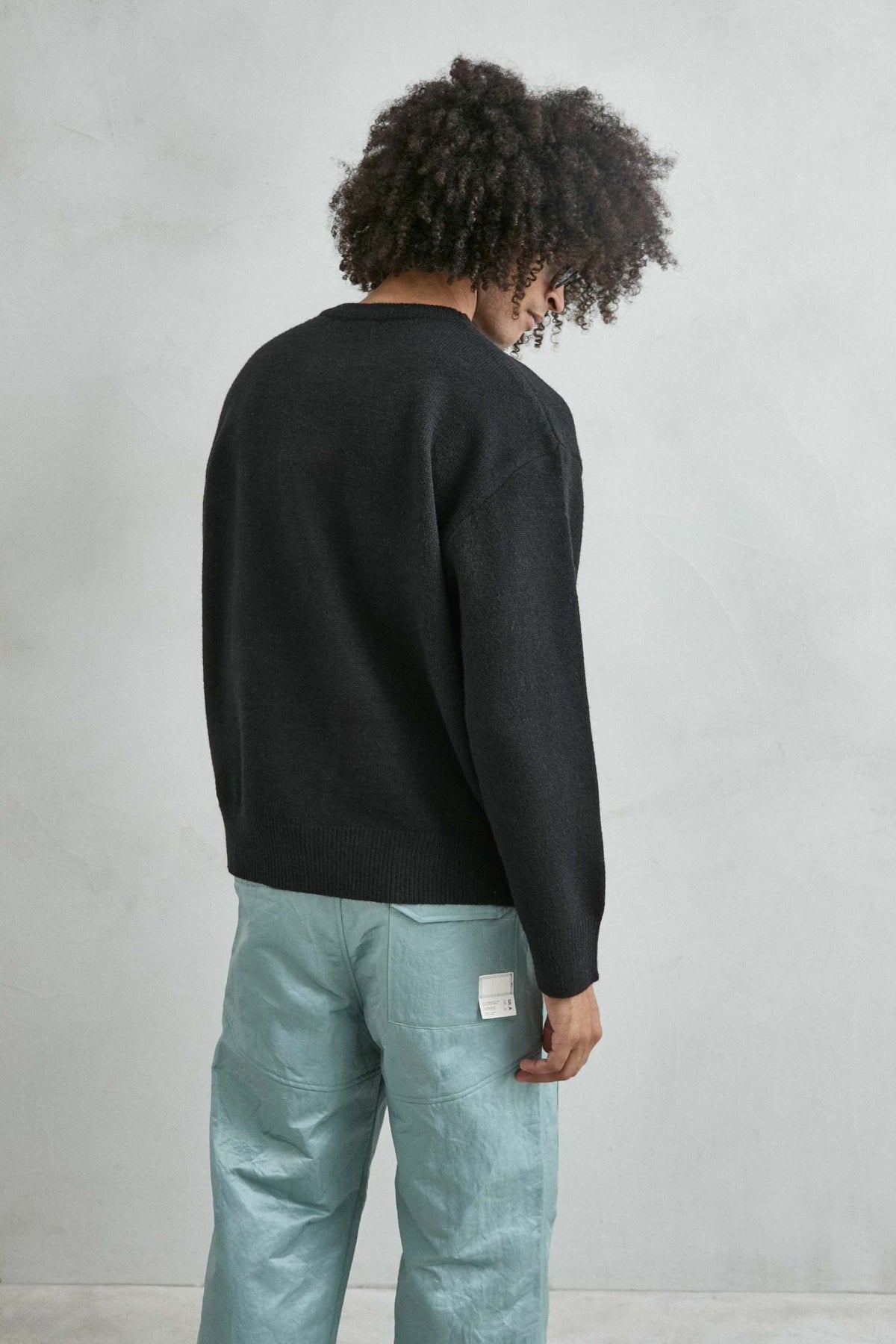 Vista trasera del jersey liso oversize de hombre en negro