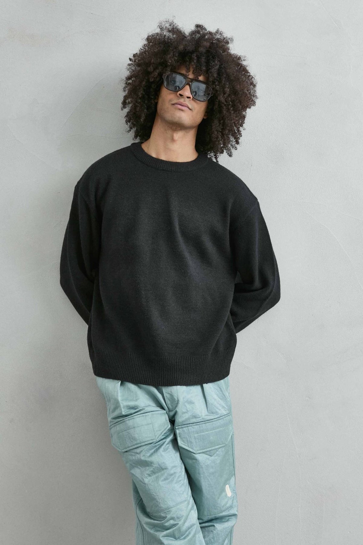 Vista frontal de medio cuerpo del jersey liso oversize de hombre en negro
