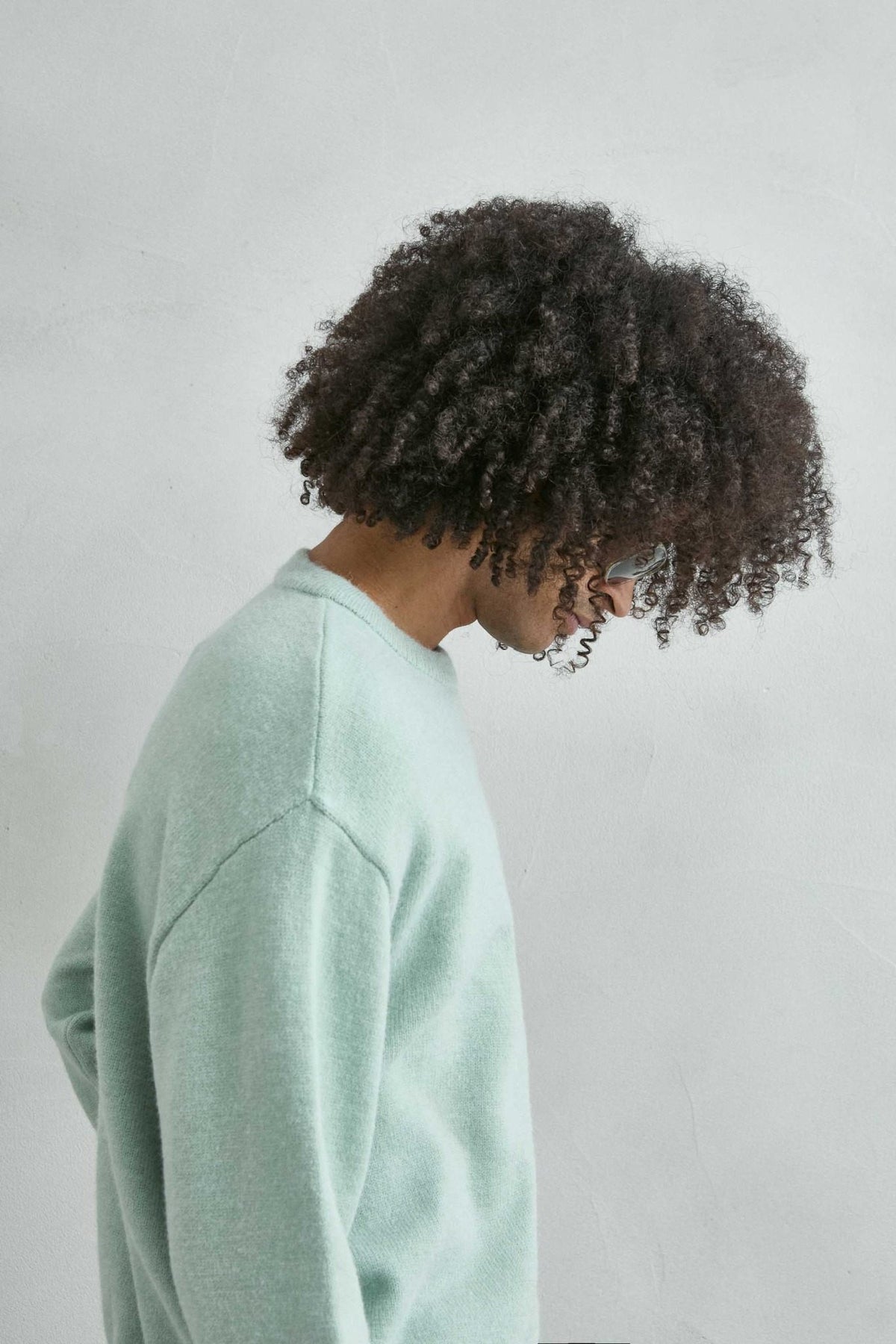Detalle del tejido de punto y los acabados del jersey liso oversize de hombre en verde menta