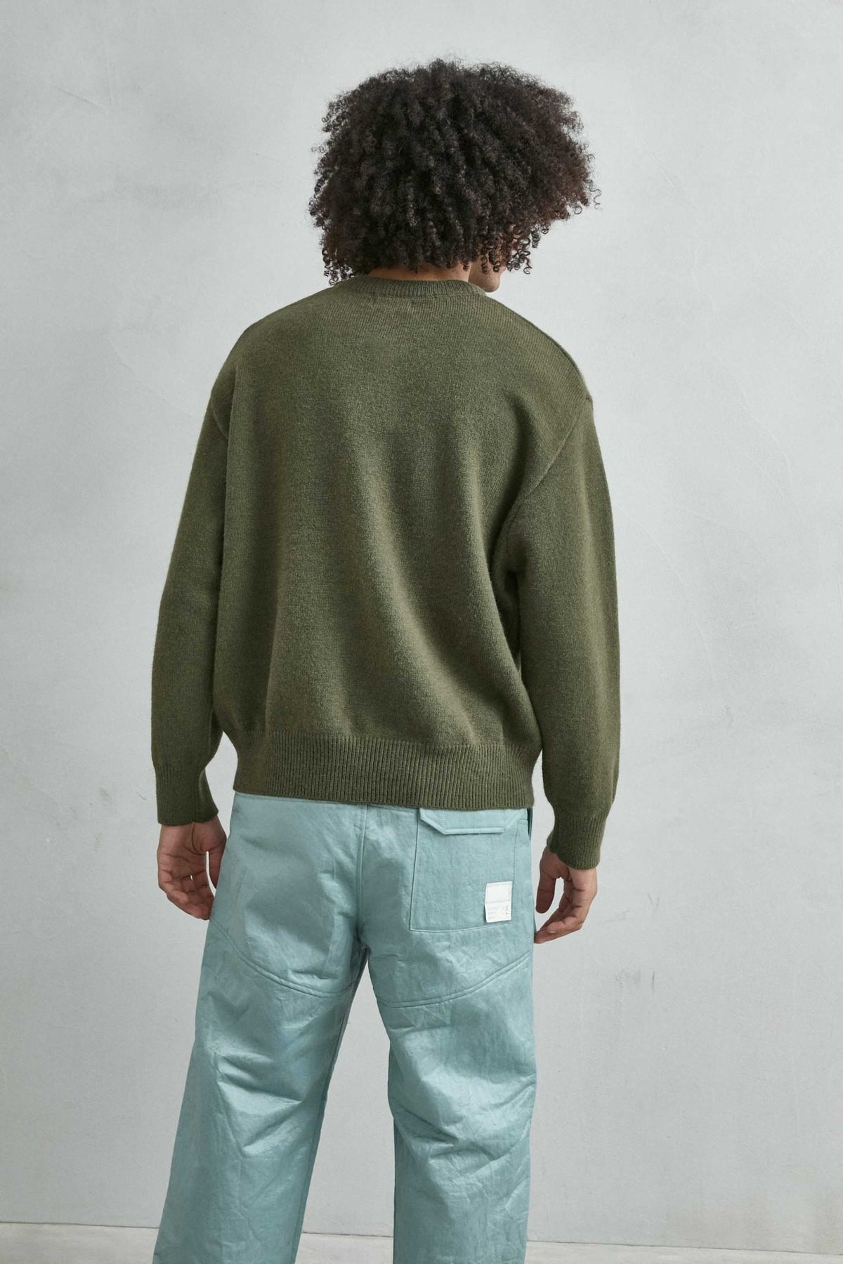 Vista trasera del jersey liso oversize de hombre en verde oliva