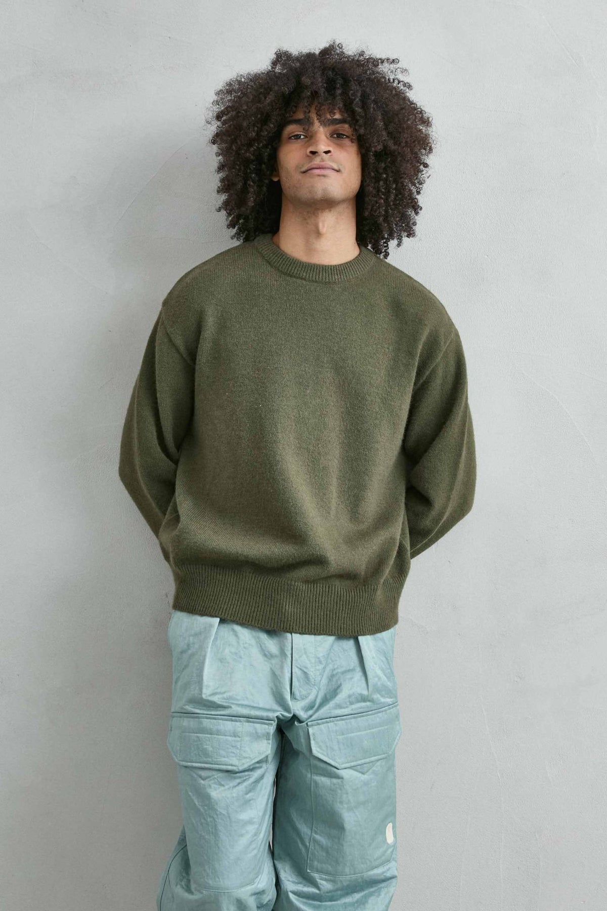 Vista frontal de medio cuerpo del jersey liso oversize de hombre en verde oliva