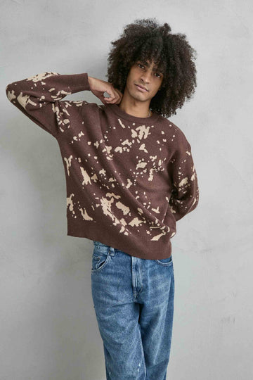 Vista frontal de medio cuerpo del jersey oversize marrón y beis con dibujo de manchas irregulares