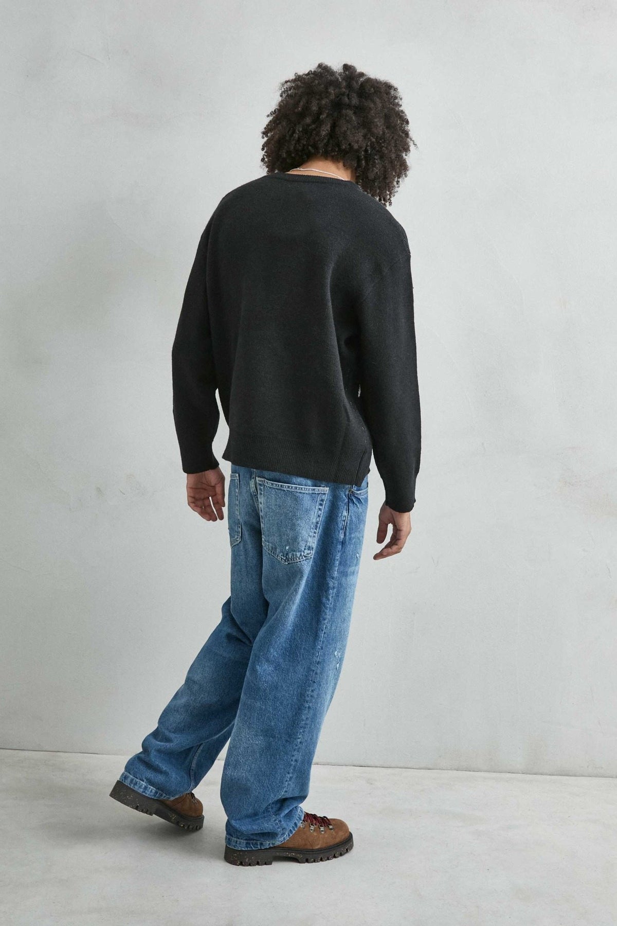 Vista trasera lisa del jersey oversize negro con dibujo arquitectónico en blanco