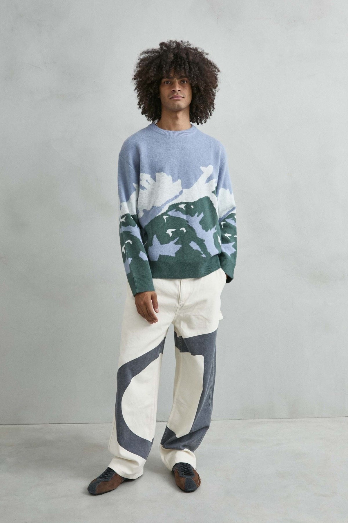 Vista de cuerpo entero del jersey oversize con dibujo abstracto de ondas en azul lila, verde y blanco