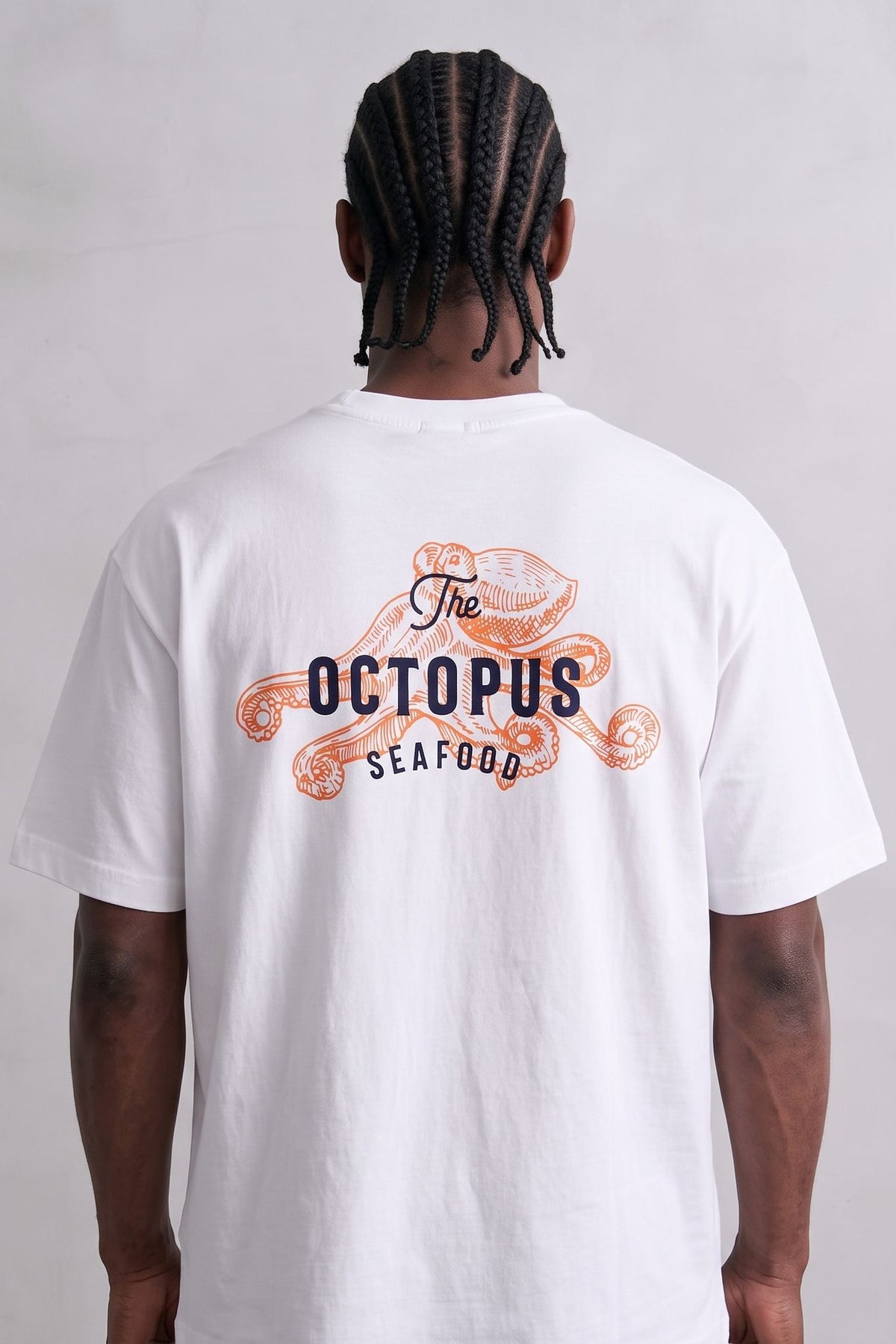 Espalda de camiseta blanca con pulpo naranja y letras The Octopus Seafood