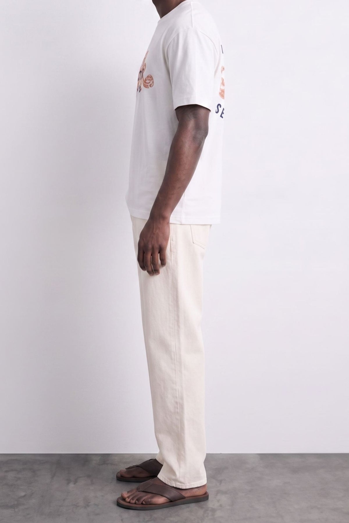 Vista lateral de camiseta blanca oversize con manga amplia