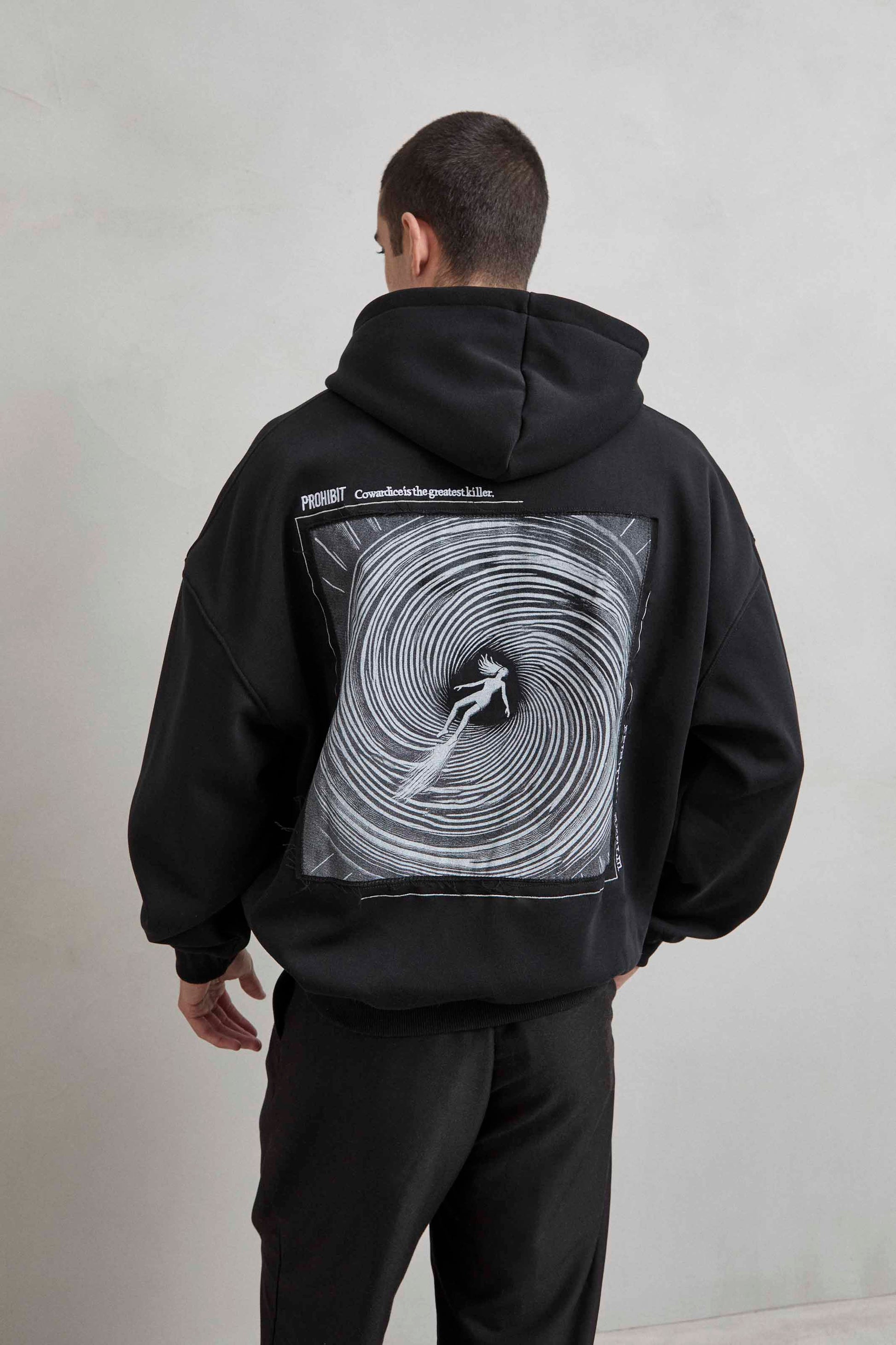 Sudadera negra con patchwork de persona cayendo en remolino