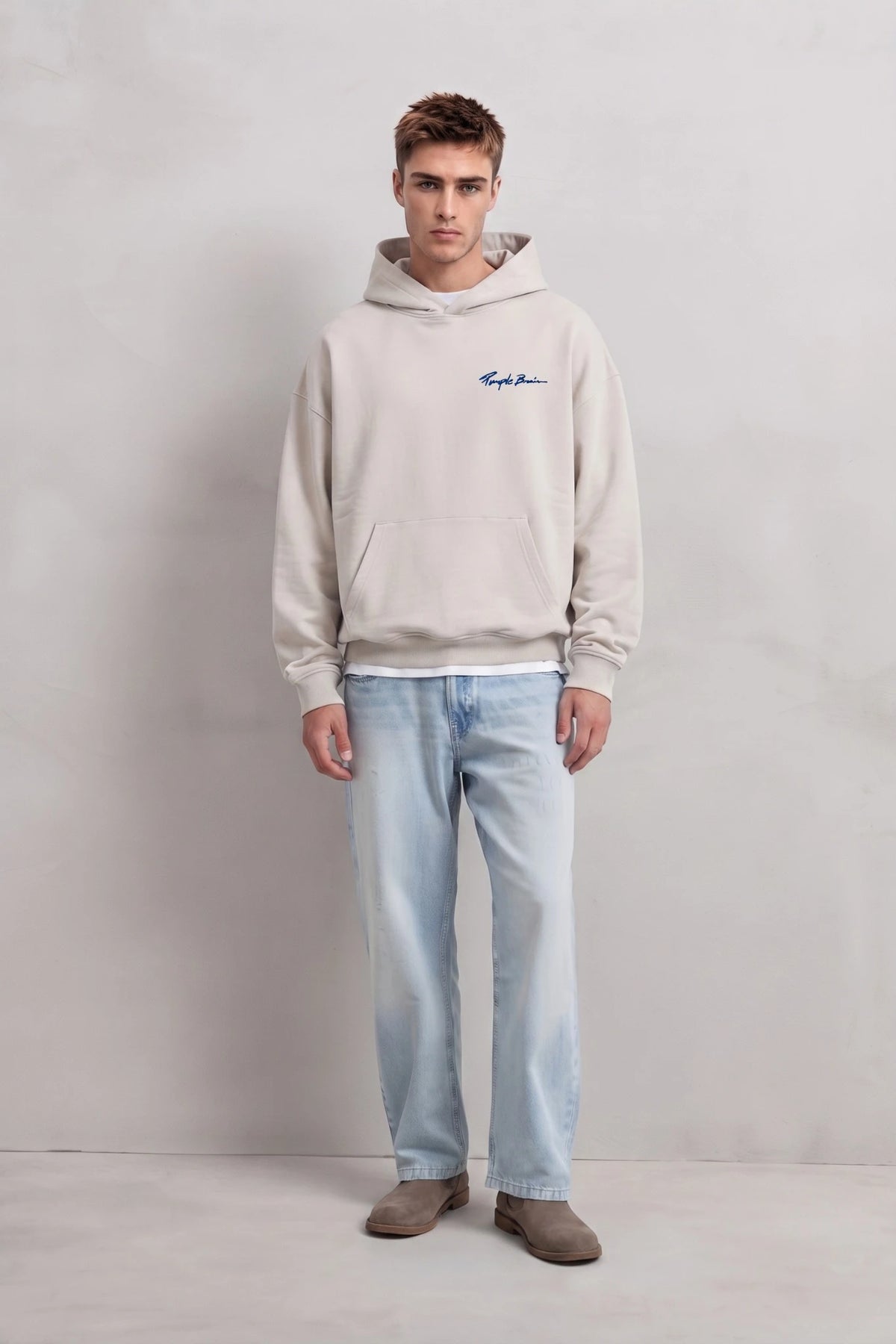 Vista frontal de cuerpo entero con sudadera beige y vaqueros claros