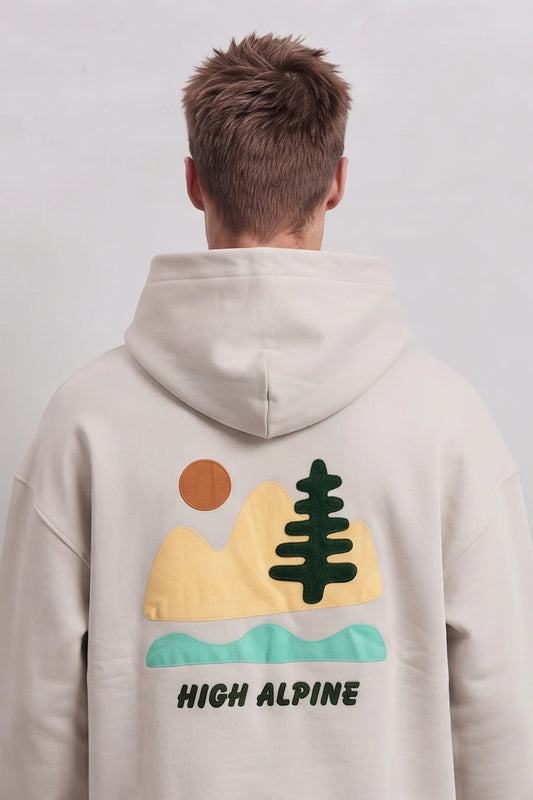 Espalda de sudadera beige High Alpine con paisaje de montañas, árbol, sol y agua en colores