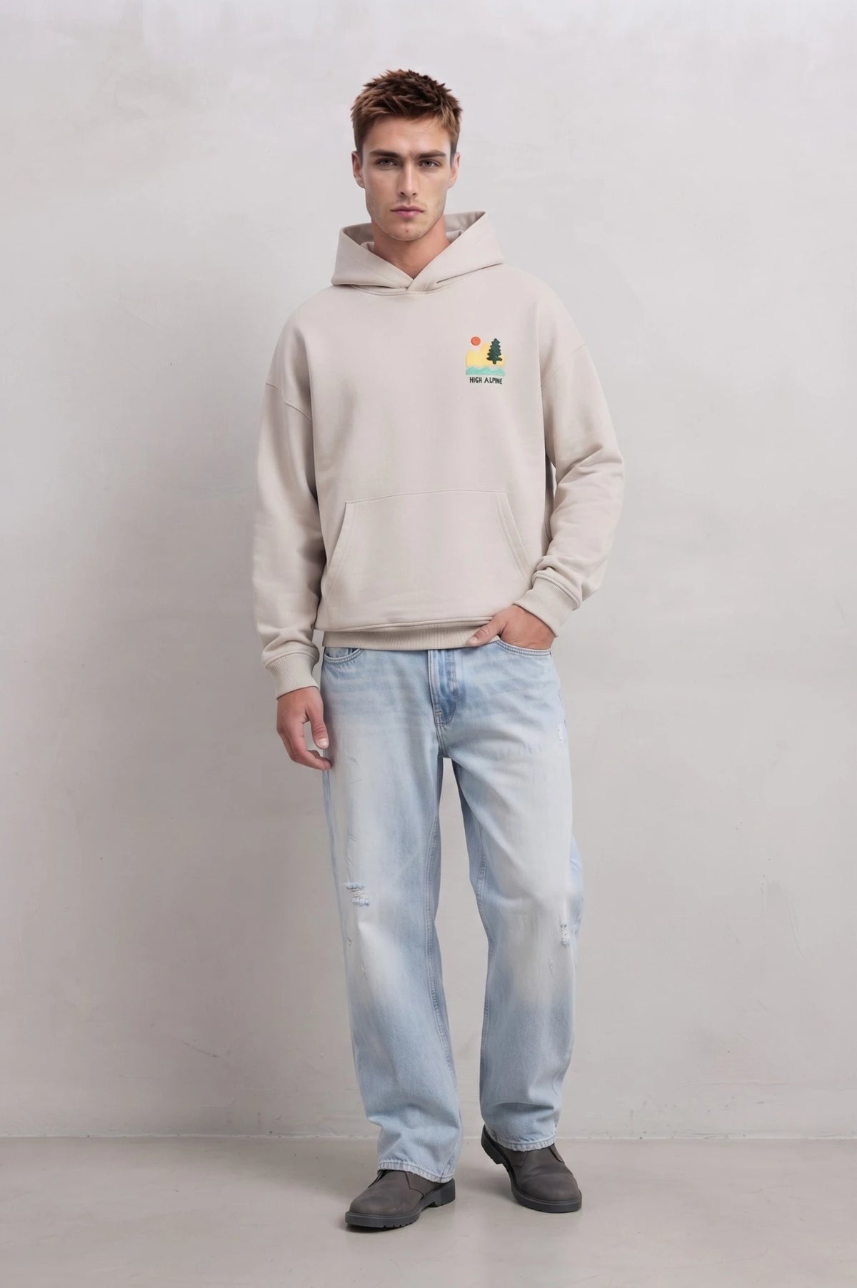 Vista frontal de cuerpo entero con sudadera beige High Alpine y vaqueros claros
