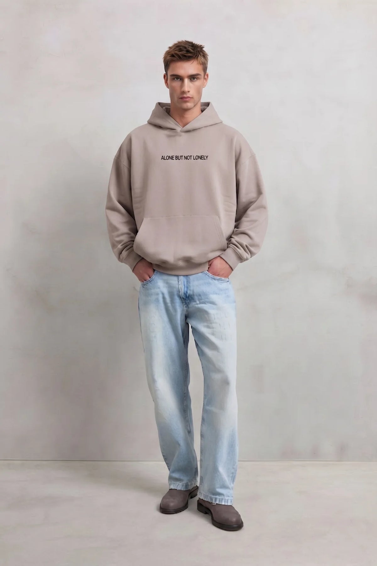 Sudadera beige oversize de hombre con capucha y letras Alone But Not Lonely en el pecho, vista frontal