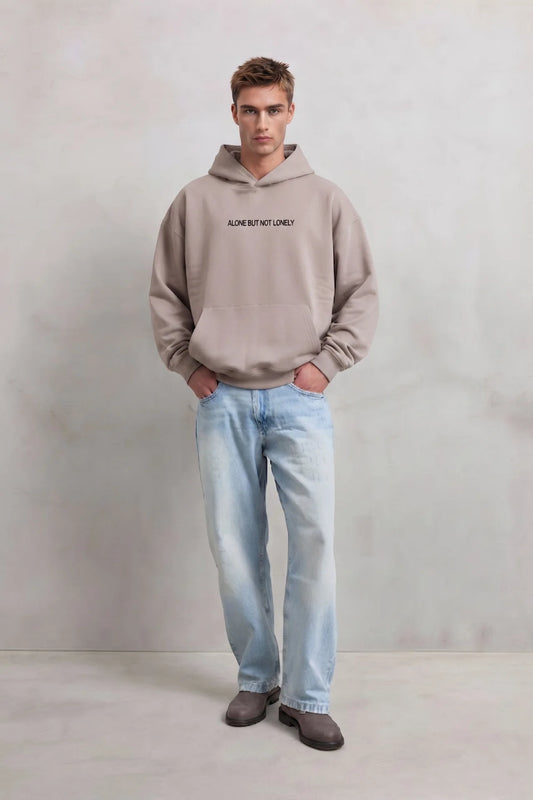 Sudadera beige oversize de hombre con capucha y letras Alone But Not Lonely en el pecho, vista frontal