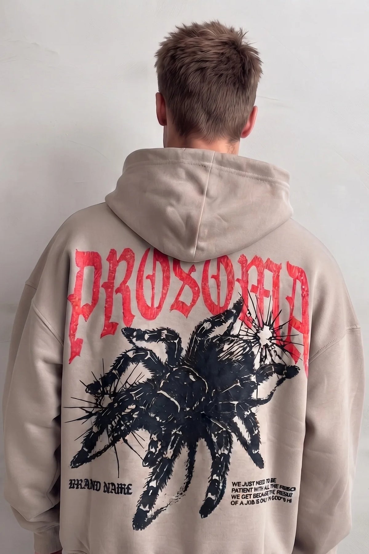 Espalda de sudadera beige con gran gráfico de araña negra y letras rojas PROSOMA