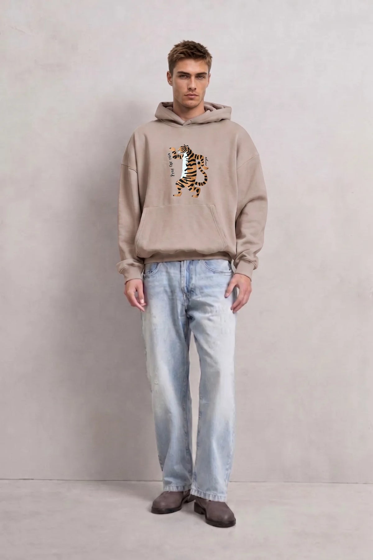 Vista frontal de cuerpo entero con sudadera beige oversize de tigre Pray for Rain y vaqueros claros