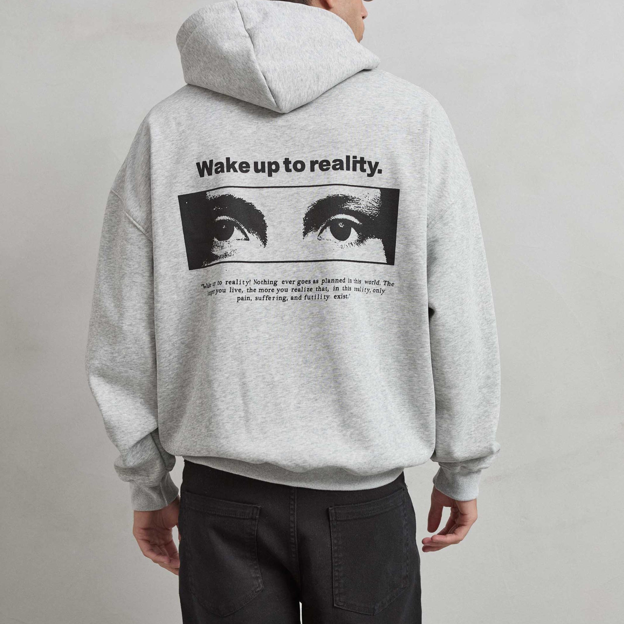 Sudadera gris jaspe con gráfico de ojos y texto “WAKE UP TO REALITY”