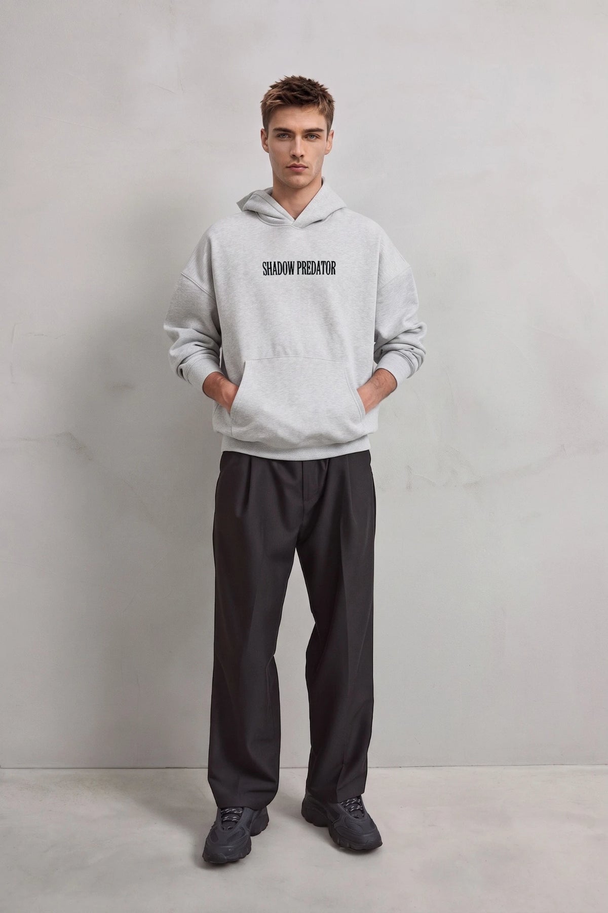 Vista frontal de cuerpo entero con sudadera gris Shadow Predator y pantalones negros