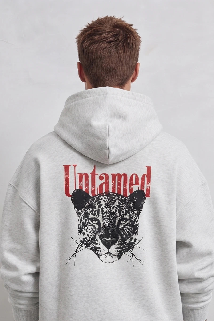 Espalda de sudadera gris con cabeza de leopardo negra y texto Untamed en rojo