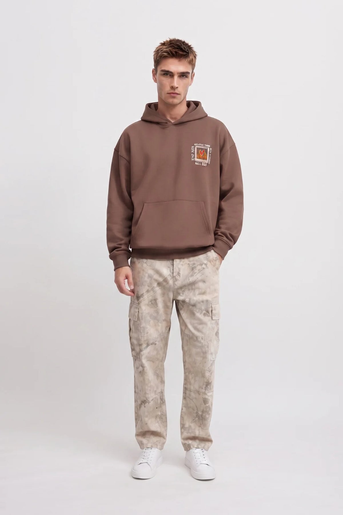 Vista frontal de cuerpo entero con sudadera marrón de corazón en llamas y pantalones cargo claros