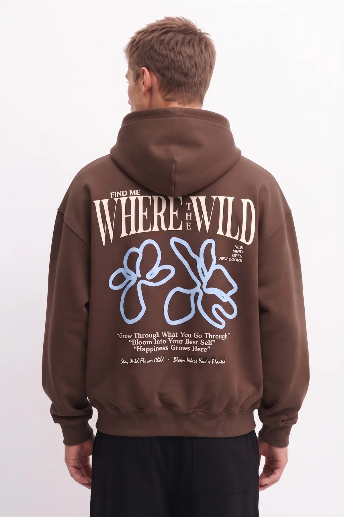 Espalda de sudadera marrón con letras Where the Wild en color crema y flores de líneas azules