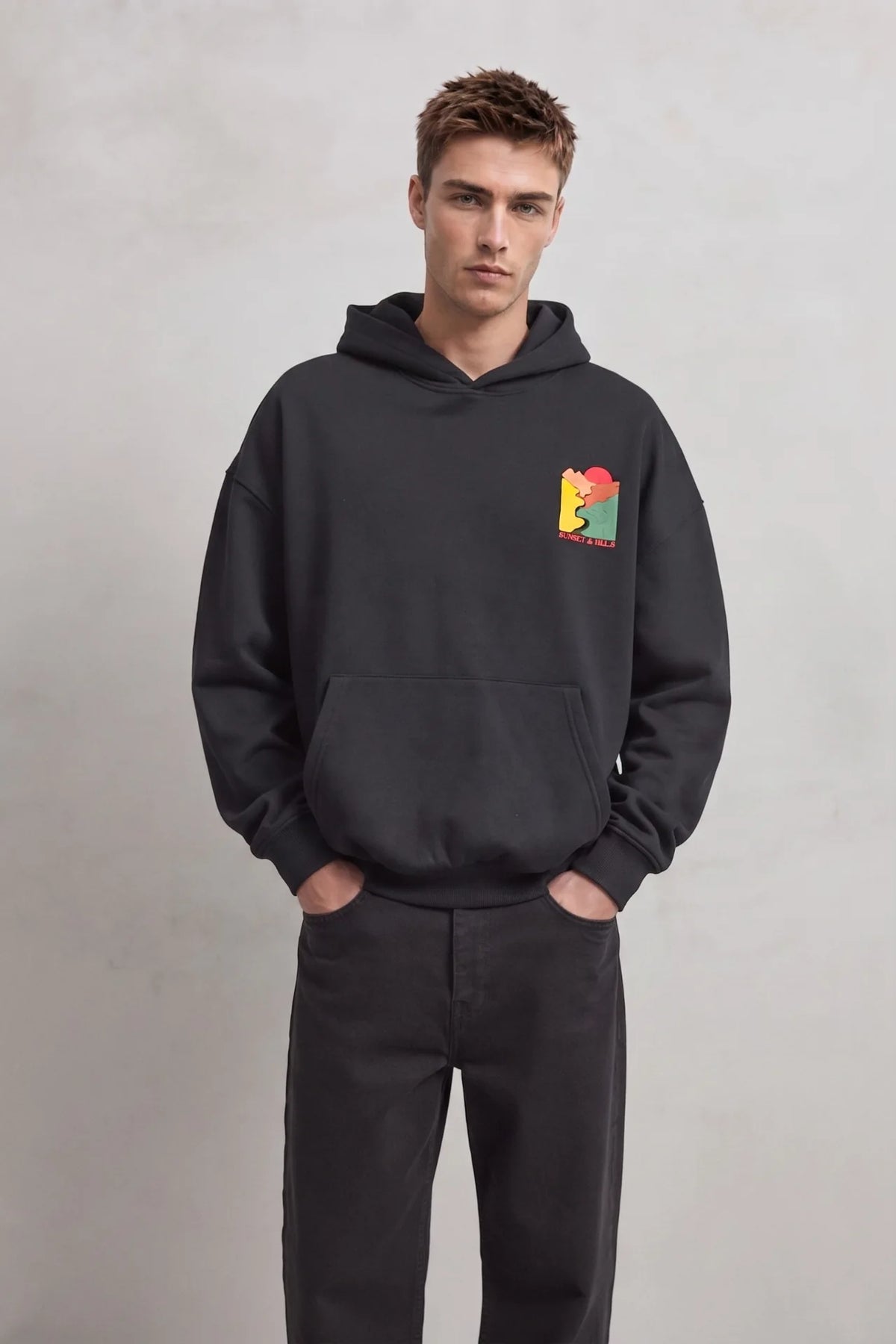 Sudadera negra oversize de hombre con capucha y pequeño gráfico de paisaje Sunset and Hills en el pecho